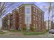 Three-story brick condo building with white trim, mature trees and landscaped grounds at 792 N Davidson St, Charlotte, NC 28202