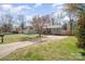 Quaint house with a tidy front lawn, driveway, and mature trees on a sunny day at 9105 Touchstone Ln, Charlotte, NC 28227