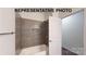 This bathroom features gray tiling surrounding the tub and shower with an added shelving niche at 942 Saturn St, Gastonia, NC 28052