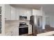 Modern kitchen with stainless steel appliances, white cabinets, and marble countertops at 942 Saturn St, Gastonia, NC 28052