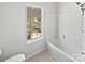 Bathroom showcasing a tub, shower with white tile surround, and a window at 9832 Veronica Dr, Charlotte, NC 28215