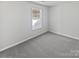 Bedroom with neutral-colored carpet, white walls, window, and outlets at 9832 Veronica Dr, Charlotte, NC 28215