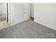 Bedroom with gray carpet and white walls. Hallway and bathroom are visible in the background at 9832 Veronica Dr, Charlotte, NC 28215