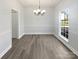 Bright dining room featuring wood floors, a chandelier, chair rail molding, and a large window for natural light at 9832 Veronica Dr, Charlotte, NC 28215