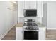 Modern kitchen island equipped with new stainless steel range and granite countertops and white cabinets at 9832 Veronica Dr, Charlotte, NC 28215