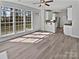 Sun-filled living room with open floor plan, wood floors, ceiling fan and adjacent kitchen offers a seamless flow at 9832 Veronica Dr, Charlotte, NC 28215