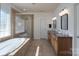 Luxurious bathroom with a soaking tub, dual vanities, and modern tile at 10005 Chimney Dr, Waxhaw, NC 28173