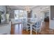 Elegant dining area with hardwood floors, large windows, decorative light fixture, and neutral wall color at 10005 Chimney Dr, Waxhaw, NC 28173
