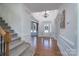 Bright foyer featuring hardwood floors, a staircase, an elegant chandelier, and a glimpse of the front door at 10005 Chimney Dr, Waxhaw, NC 28173