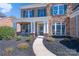 Charming home exterior with stone accents, a cozy porch, and verdant landscaping leading to the front door at 10005 Chimney Dr, Waxhaw, NC 28173
