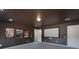 Spacious home theater room with a blank projector screen, movie posters, neutral carpet, and dark brown walls at 10005 Chimney Dr, Waxhaw, NC 28173