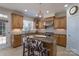 Well-lit kitchen with granite island, stainless appliances, and wooden cabinetry throughout at 10005 Chimney Dr, Waxhaw, NC 28173