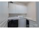 Functional laundry room featuring a washer, dryer, utility sink, and plenty of overhead cabinet storage space at 10005 Chimney Dr, Waxhaw, NC 28173