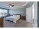Spacious main bedroom featuring a plush bed, tray ceiling, and adjoining bathroom at 10005 Chimney Dr, Waxhaw, NC 28173