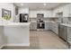 Modern kitchen features white and gray cabinets, stainless appliances, quartz countertops, and tiled backsplash at 1001 Churchill Downs Ct # A, Charlotte, NC 28211