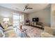 Cozy living room featuring a ceiling fan, hardwood floors, and a sliding door to the outdoor balcony at 1001 Churchill Downs Ct # A, Charlotte, NC 28211