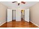 Empty bedroom with hardwood floors, ceiling fan and double doors to closet and en suite bathroom at 103 S Laurel Ave, Charlotte, NC 28207