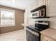 Kitchen with stainless steel microwave, oven, tile backsplash, and white cabinets at 103 S Laurel Ave, Charlotte, NC 28207