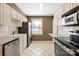 Compact kitchen featuring stainless steel appliances, white cabinetry and tile flooring at 103 S Laurel Ave, Charlotte, NC 28207