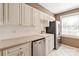 Kitchen featuring stainless steel appliances, white cabinets, and tile backsplash at 103 S Laurel Ave, Charlotte, NC 28207