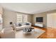 Bright living room featuring neutral walls, modern furniture, and hardwood floors with a view out the window at 103 S Laurel Ave, Charlotte, NC 28207