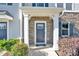 Front door with stone detail, white columns, and a 'Welcome Ryan Homes' mat at 1128 Newell Towns Ln, Charlotte, NC 28262