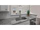Bright kitchen features granite countertops and stainless steel sink overlooking the living area at 11332 Westbranch Pkwy, Davidson, NC 28036