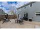 View of the concrete patio, table set, patio swing, grill, and backyard of the two-story home at 12109 Sawtry Ct, Pineville, NC 28134