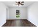 Bright bedroom with dark hardwood floors, a ceiling fan, and a window showcasing the outdoor scenery at 12109 Sawtry Ct, Pineville, NC 28134