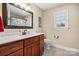 Well-lit bathroom featuring a wood vanity, large mirror, and pristine toilet and tile floors at 1263 Waterford Dr, Hickory, NC 28602