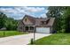 Two-story home featuring stone and shingle siding with a two-car garage and a well-manicured lawn at 1263 Waterford Dr, Hickory, NC 28602