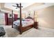 Spacious main bedroom with a four-poster bed, neutral carpet, and tray ceilings at 1263 Waterford Dr, Hickory, NC 28602