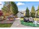 Well-maintained backyard with a shed, playset, and mature trees at 12836 Harvest Time Ct, Charlotte, NC 28278
