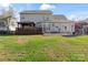 Expansive backyard view featuring a spacious deck, patio, and lush lawn at 12836 Harvest Time Ct, Charlotte, NC 28278