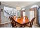 Traditional dining room featuring gray walls, hardwood floors, a chandelier, and backyard views at 12836 Harvest Time Ct, Charlotte, NC 28278