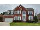 Charming two-story brick home featuring a well-manicured lawn and a classic architectural design at 12836 Harvest Time Ct, Charlotte, NC 28278