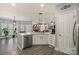 Bright kitchen features island seating, modern lighting, and white cabinetry at 12836 Harvest Time Ct, Charlotte, NC 28278