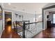 Open landing area with dark hardwood floors and decorative lighting fixture at 12836 Harvest Time Ct, Charlotte, NC 28278