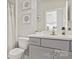 A serene bathroom featuring a gray vanity, modern fixtures, and a shower with a patterned curtain at 132 Asmodean Ln, Troutman, NC 28166