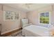 Bright bedroom with a white bed frame, three large windows and wood floors at 138 Scofield Rd, Charlotte, NC 28209