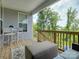 Relaxing covered balcony with seating, a small table, and views of a lush backyard at 14230 Morningate St, Huntersville, NC 28078