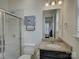 Modern bathroom featuring a glass-enclosed shower, granite vanity, and sleek fixtures at 14230 Morningate St, Huntersville, NC 28078