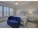 Serene bedroom featuring a large bed, a cozy chaise lounge, and bright natural light from the windows at 14230 Morningate St, Huntersville, NC 28078