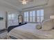 Bright bedroom featuring a spacious bed with a tufted headboard and shuttered windows at 14230 Morningate St, Huntersville, NC 28078