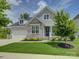 Charming two-story home with a stone facade, well-manicured lawn, and a welcoming front porch at 14230 Morningate St, Huntersville, NC 28078