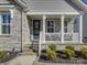 Inviting front porch with stone accents, steps, a charming wreath, and a cozy seating area at 14230 Morningate St, Huntersville, NC 28078