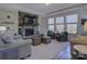 Cozy living room featuring a stone fireplace, mantle-mounted TV, and natural light from large windows at 14230 Morningate St, Huntersville, NC 28078