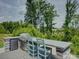 Modern outdoor kitchen with a built-in grill, bar seating, and lush green surroundings at 14230 Morningate St, Huntersville, NC 28078