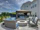 Stylish outdoor patio with a fire pit, comfortable seating, and a covered dining area with a TV at 14230 Morningate St, Huntersville, NC 28078