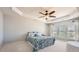 Spacious bedroom with tray ceilings, a ceiling fan, many windows, and a bed with bright comforter at 15317 Colonial Park Dr, Huntersville, NC 28078